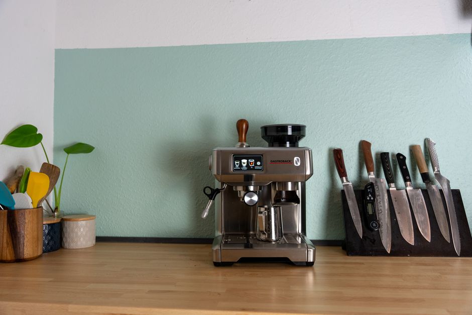 Sleek espresso machine with knives in a stylish kitchen setting.