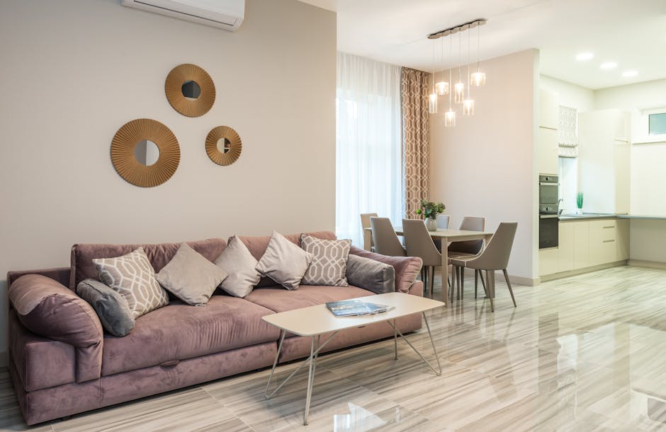 Modern interior design of flat with comfortable couch in stylish living room with kitchen equipped with built in appliances